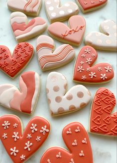 many decorated heart shaped cookies on a table