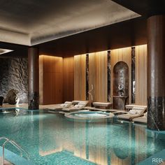 an indoor swimming pool with chaise lounges next to it and stone walls around it