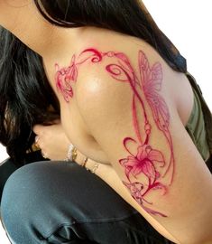 a woman with a dragon tattoo on her shoulder and chest, sitting in front of a white background