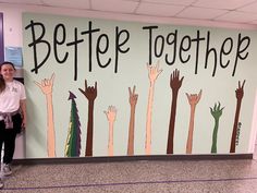 a girl standing in front of a sign that says better together with hands painted on it