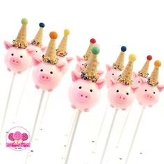 five pink pigs with party hats on top of them are sitting on toothpicks