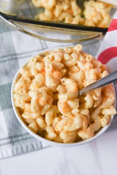 a bowl filled with macaroni and cheese on top of a checkered table cloth