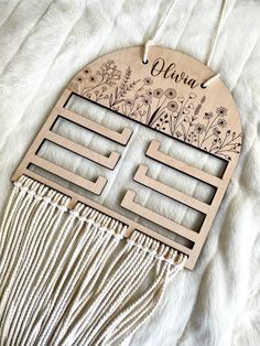 a wooden comb with flowers and the words flora on it is laying on a white blanket