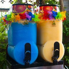 two colorful drinks are sitting on top of a toaster with sunglasses and hula leis