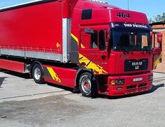 a red semi truck parked in a parking lot