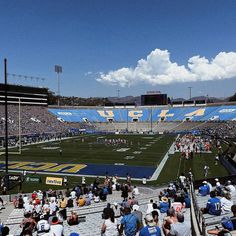 a stadium filled with lots of people sitting on the bleachers watching a football game