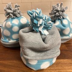 two blue and white polka dot hats on top of a wooden table