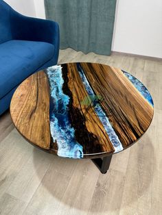 a blue couch sitting next to a wooden table on top of a hard wood floor