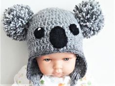 a baby wearing a knitted koala hat