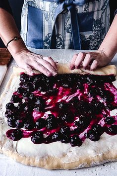 the woman is making a homemade blueberry pie