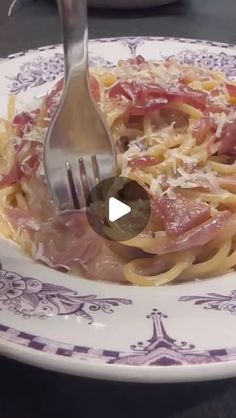 the fork is being used to eat pasta with ham and cheese on it's side