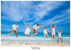 a group of people jumping in the air at the beach