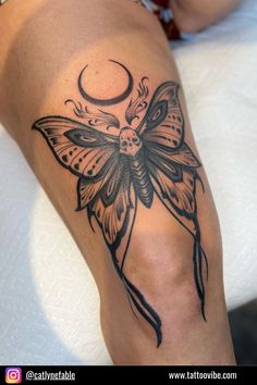 a woman with a butterfly tattoo on her leg and the moon in the sky behind her