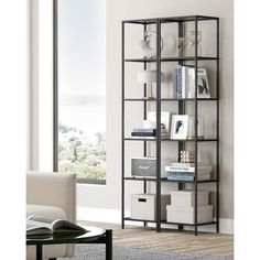 a book shelf with many books on it in a living room next to a window