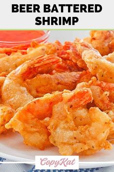 a plate full of shrimp and beer battered shrimp with ketchup on the side