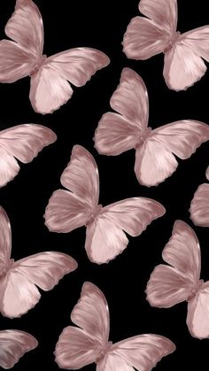 pink butterflies flying in the air on a black background