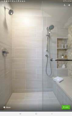 a walk in shower sitting next to a white counter top under a light on the wall