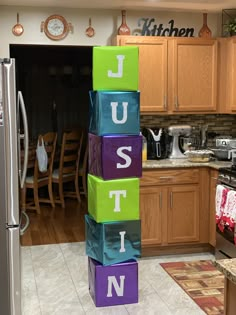 colorful blocks spelling out the word just in front of a kitchen