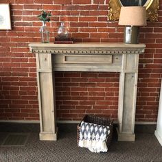 a fireplace with a basket underneath it and a lamp next to it on the floor