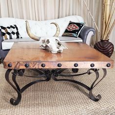 a living room with a couch, coffee table and cow skull on the top of it