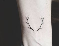 a deer's antlers with a triangle tattoo on the ankle