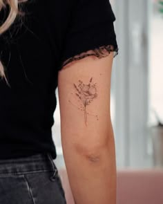 a woman with a flower tattoo on her arm