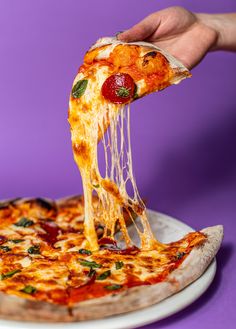 a person taking a slice of pizza from a plate