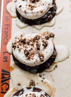 three desserts with whipped cream and chocolate on top are lined up next to a measuring tape