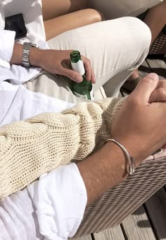 a person sitting on a chair holding a bottle