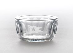 an empty glass bowl sitting on top of a table