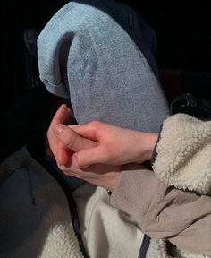 a person holding their hands together while sitting in a car