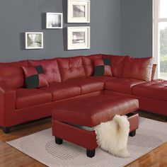 a living room with red leather furniture and pictures on the wall