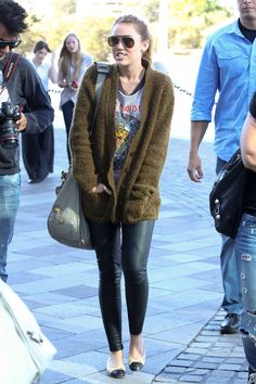 a woman walking down the street with her hand in her pocket