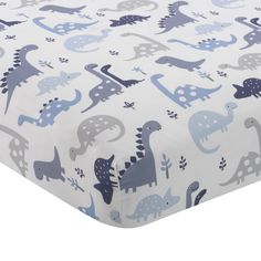 a close up of a bed sheet with blue and gray dinosaurs on the sheets