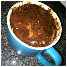 a blue mug filled with brown liquid on top of a counter