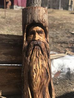 a wooden carving of a man's face on the side of a tree