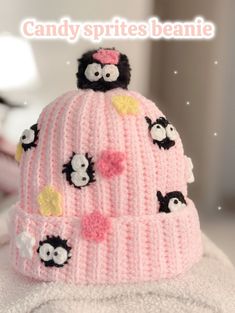 a pink knitted hat with black and white sheep on it