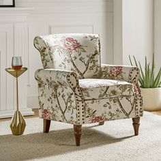 a chair sitting on top of a white rug next to a potted plant in a living room