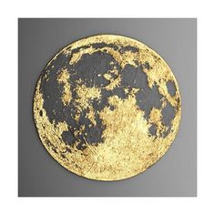 a black and gold plate with the moon on it's side, against a gray background