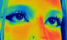 an image of a woman's face with blue and yellow colors on her eyes