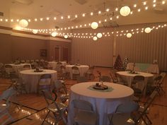 a banquet room set up with round tables and white tablecloths on the floor