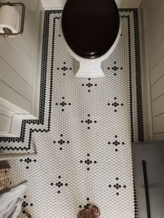 a bathroom with black and white tiles on the floor