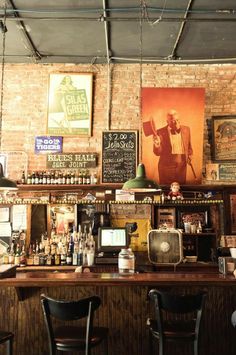 the bar is full of liquor bottles and old fashioned posters on the wall above it