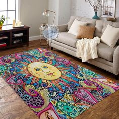 a living room area with a couch, coffee table and colorful rug on the floor