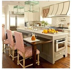 a kitchen with an island, stove and oven in it's center area that has several chairs around it