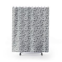 a white shower curtain with black and white designs on the front, against a white background