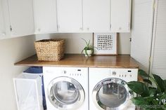 a washer and dryer sitting next to each other in a room with white cabinets