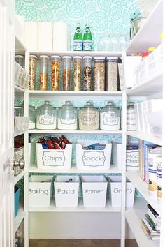 an organized pantry with plastic containers and bins filled with cereal, pasta, crackers and other items