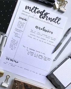 the contents of a notebook, pens and other items on a white table with black writing