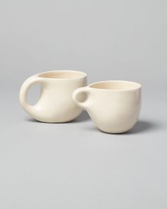 two white cups sitting next to each other